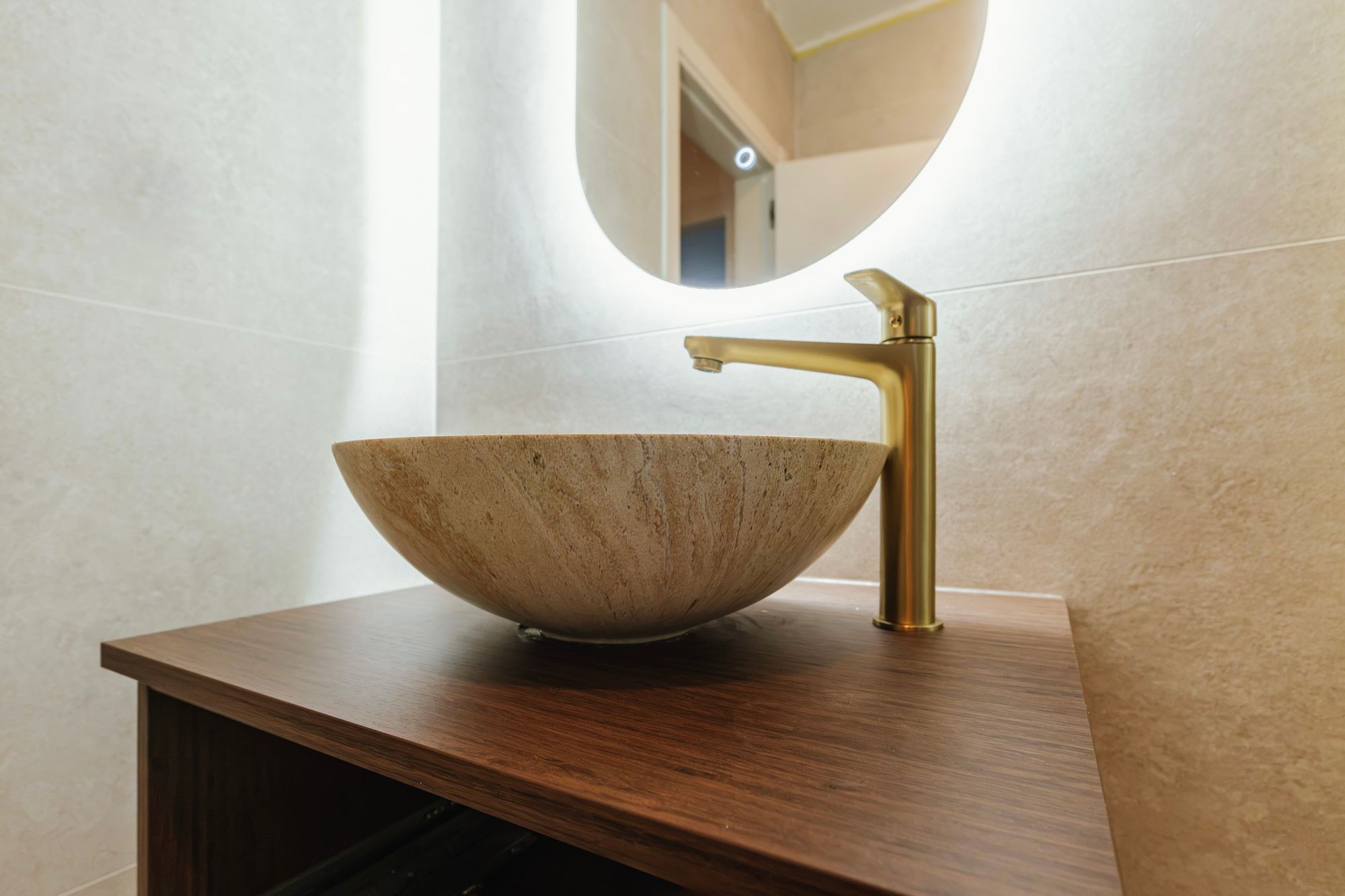 Bathroom cabinet in Brown Tonsberg Oak with a travertine washbasin and gold tap, Croatia – Krk.