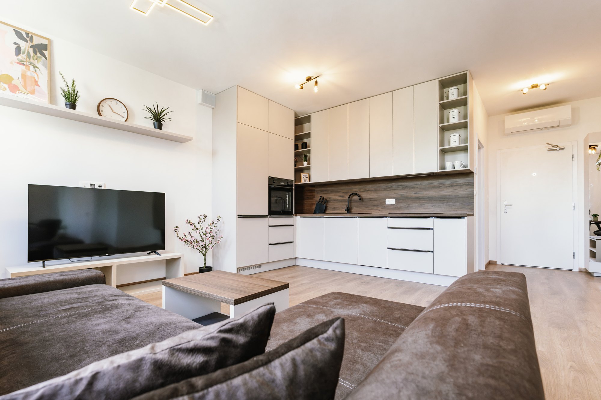 A Cashmere Grey kitchen with tall floor-to-ceiling cabinets and a splashback in Brown Warmia Walnut decor, Bratislava.