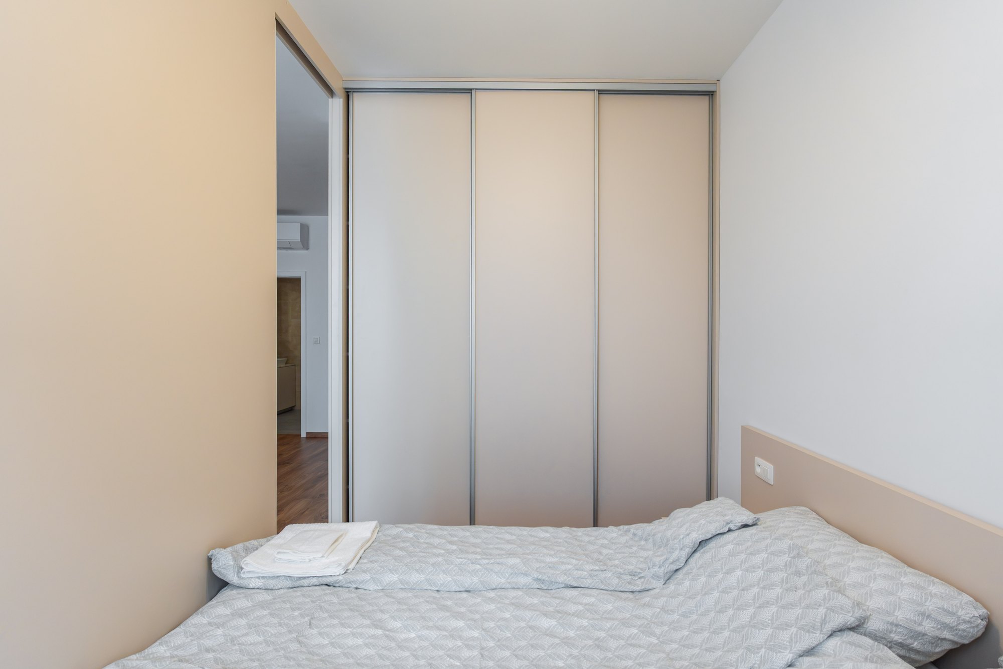 Built-in wardrobe with gable sliding doors in Satin & Black Pietra Grigia, laminated chipboard, bedroom in Bratislava.