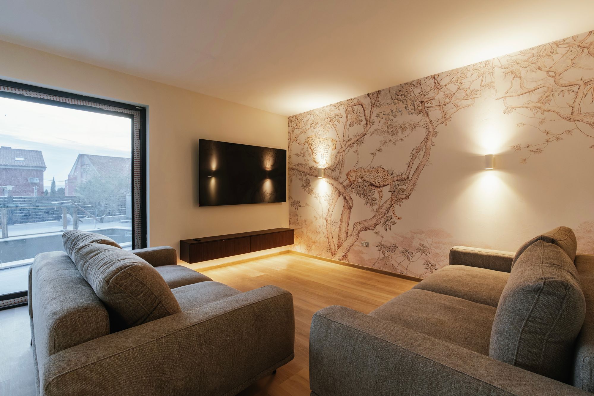 Living room with a low wall-mounted TV cabinet in Brown Tonsberg Oak and Margalida Travertine décor under the television, Croatia – Krk.