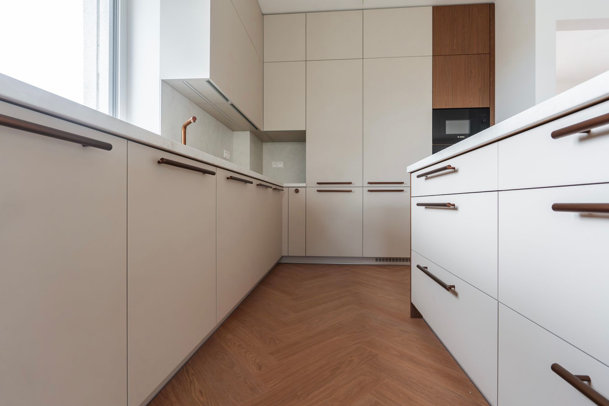 Kitchen unit in cashmere with tall floor-to-ceiling cabinets and Brown Casella Oak décor, Rovinka.