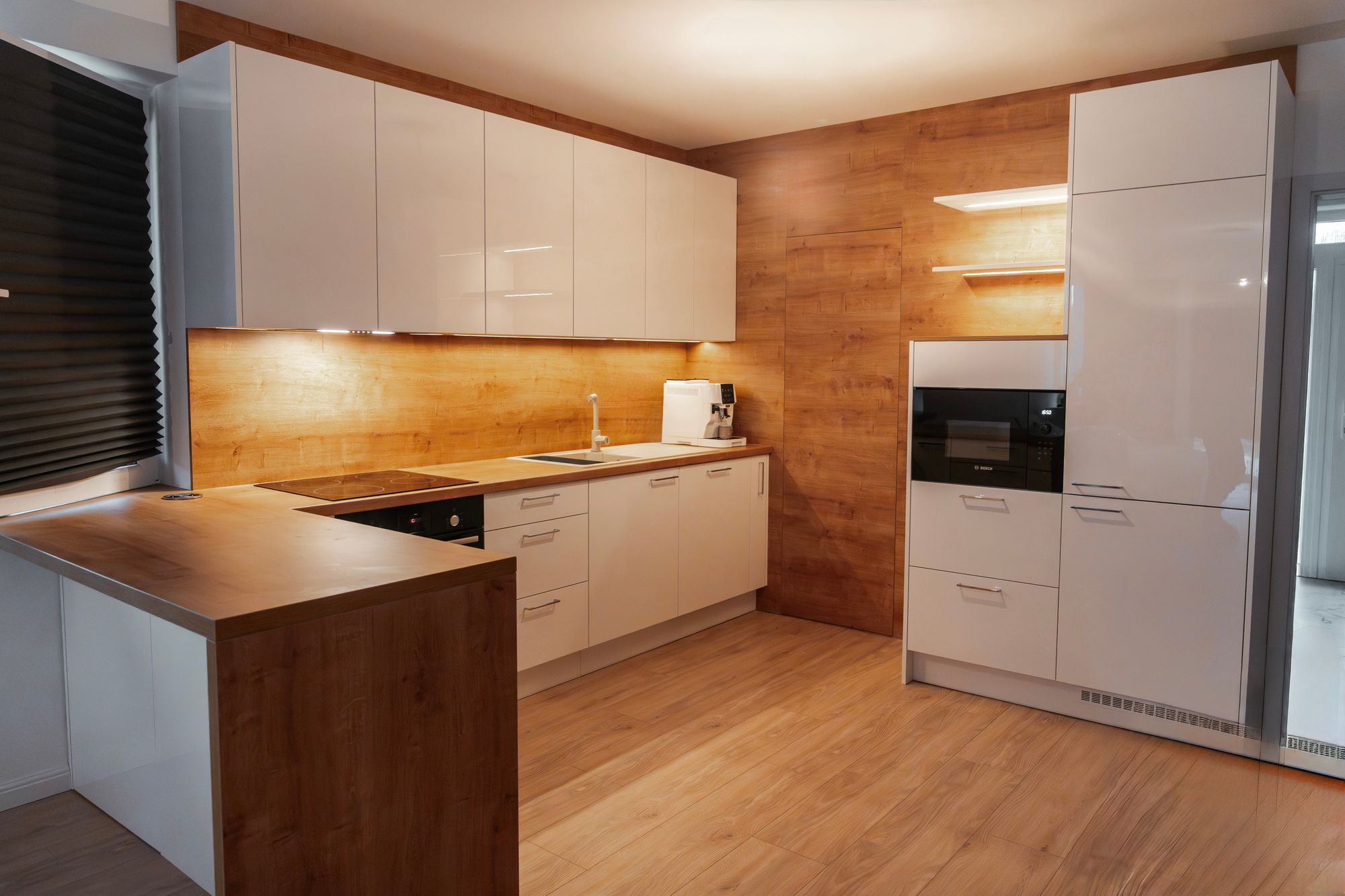 U-shaped kitchen with gloss white cabinets and a worktop in natural Hamilton oak decor, Veľký Biel.