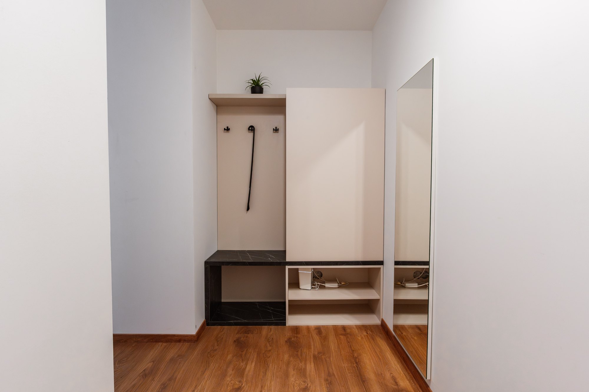 Custom-made hallway wardrobe with a coat rail, open shelves and a black Pietra Grigia-effect panel, Bratislava.