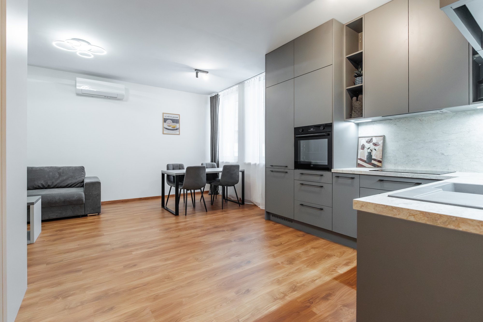 Kitchen with tall floor-to-ceiling units in dusty grey, worktop in San Luca Marble decor, Bratislava.