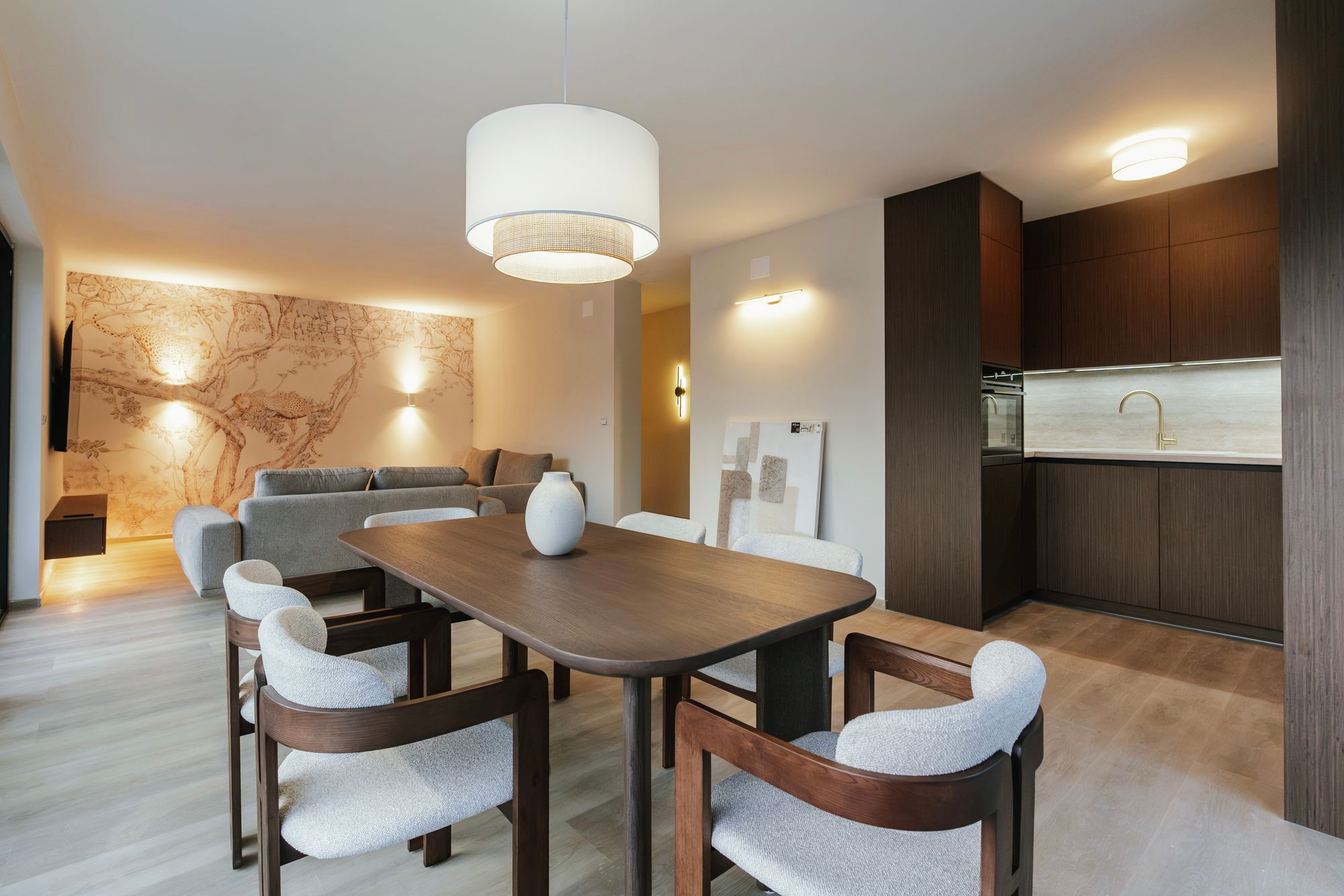 Living room with a dining table and a bespoke kitchen unit in Brown Tonsberg Oak with a Margalida Travertine worktop, Croatia – Krk.