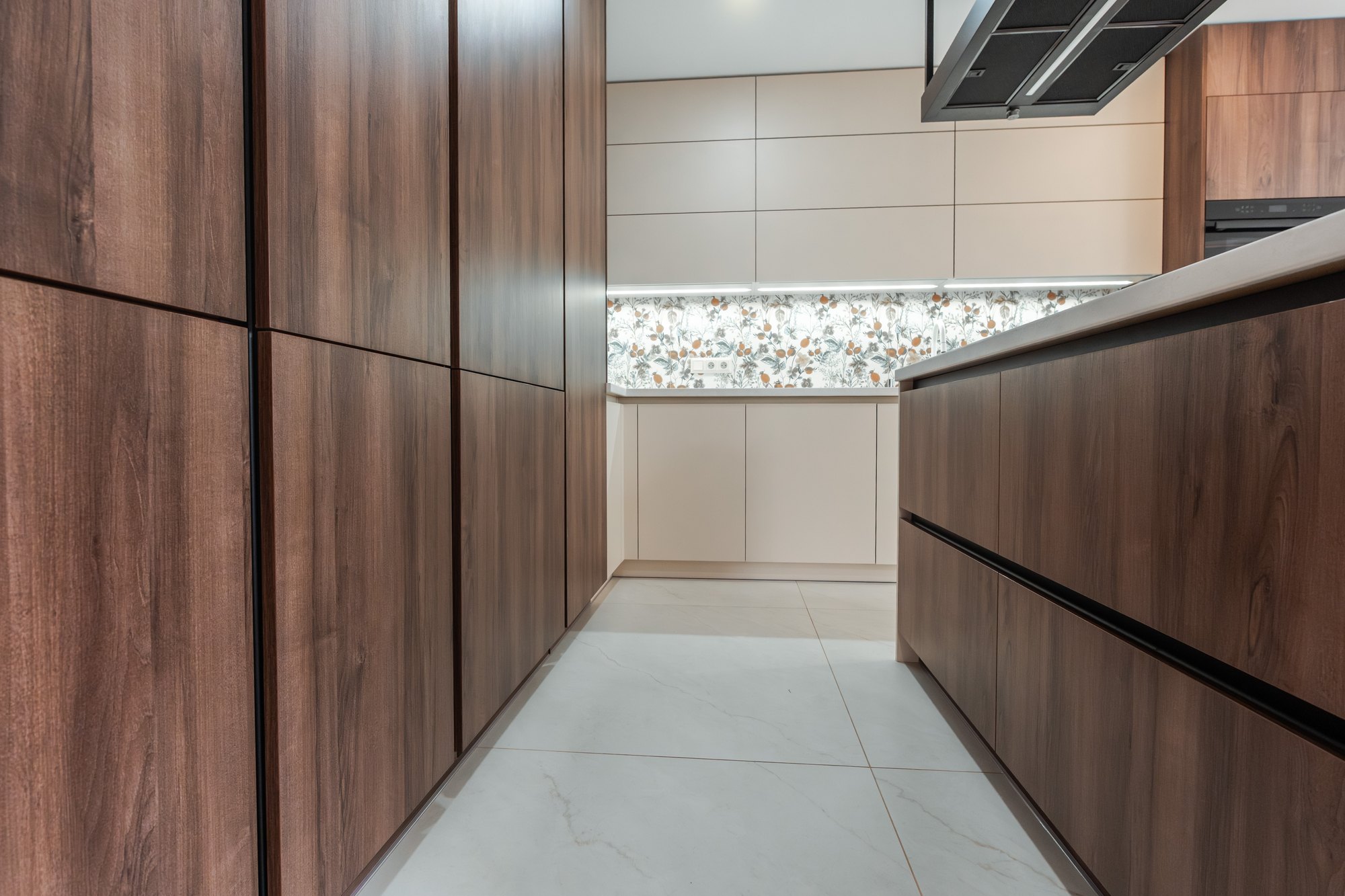 Kitchen unit with tall cabinets in Tobacco Pacifik Walnut decor and light Satin units, Cremona Marble worktop, Borský Mikuláš.