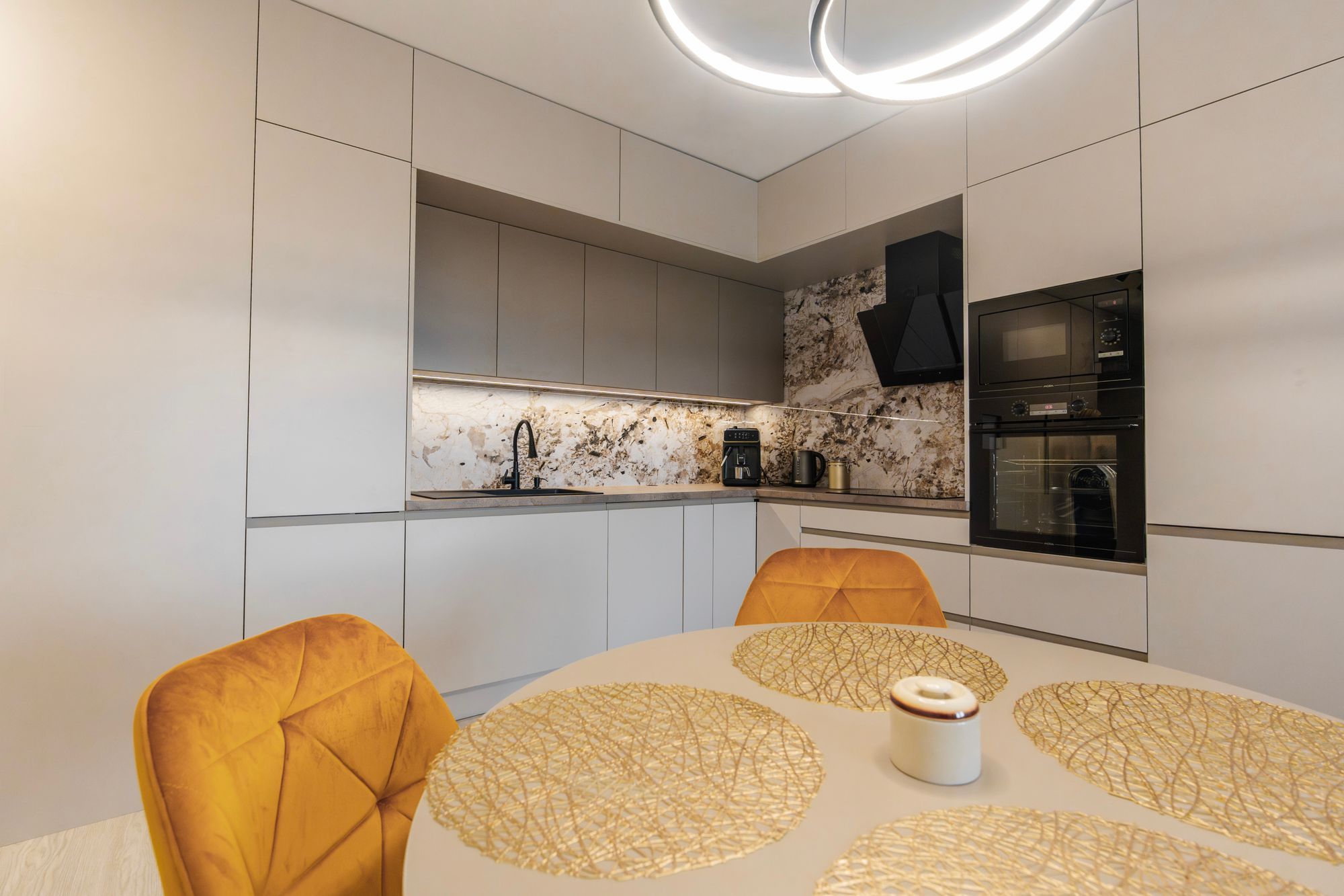 Ceiling-height fitted kitchen in Cashmere Grey and Stone Grey with a marble splashback and built-in appliances, Bratislava.