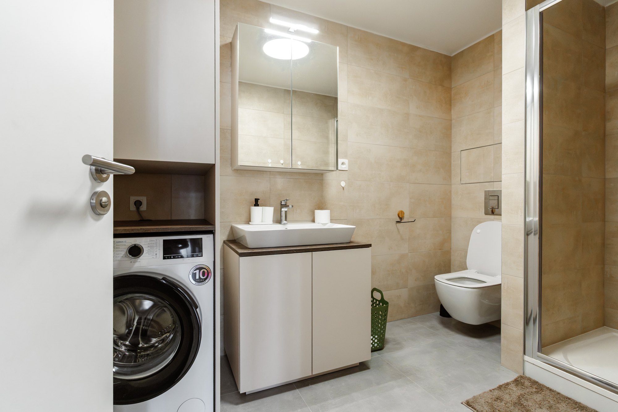 Bathroom vanity unit with space for a washing machine, in Satin and Brown Davos Oak laminate, Bratislava.