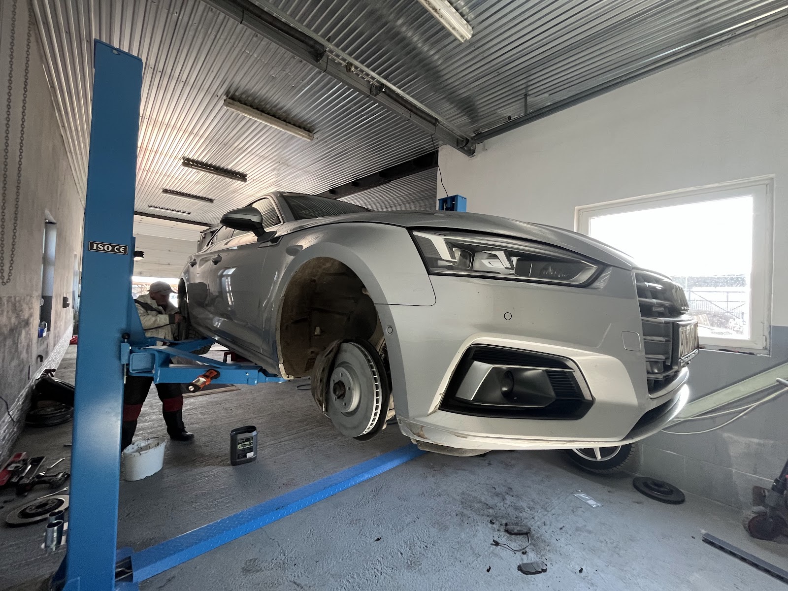 Servisný technik pri práci na vozidle v dielni CARTIRES