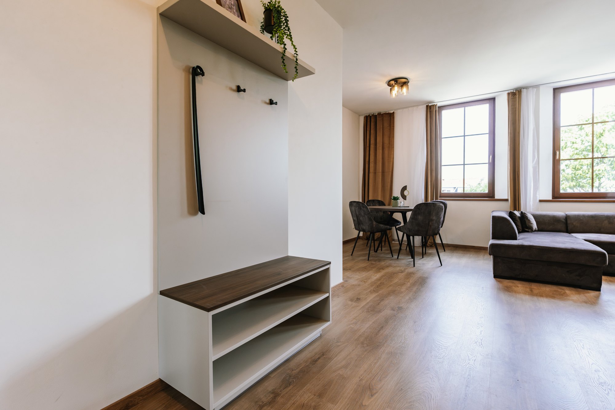 A built-in hallway wall unit with open shelves combining Cashmere Grey and Brown Warmia Walnut, laminated chipboard, Bratislava.