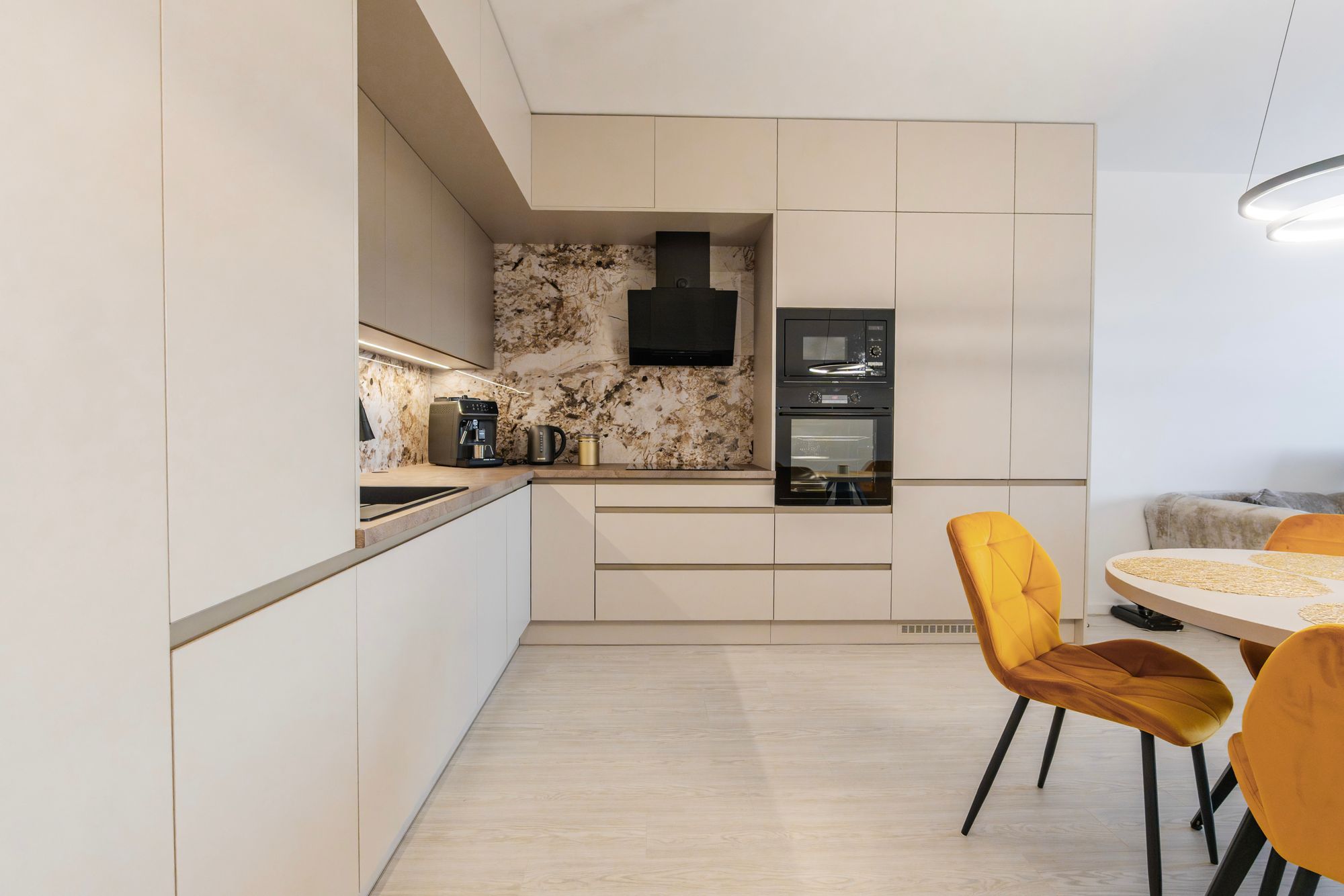 L-shaped fitted kitchen in Cashmere Grey and Stone Grey laminate with a Titanit Sandy Beige worktop and tall cabinets up to the ceiling, Bratislava.