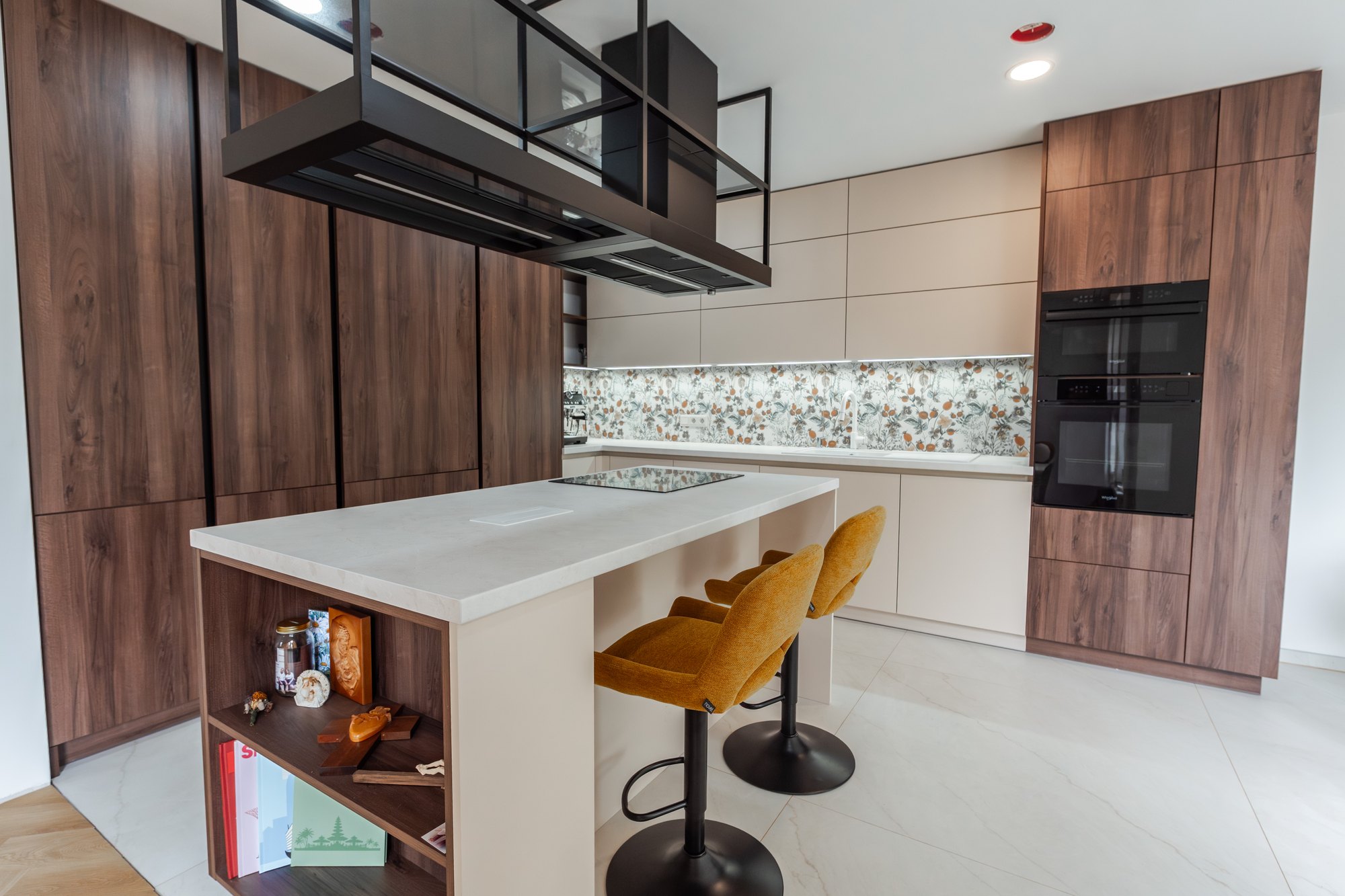 Kitchen unit with an island in Tobacco Pacifik Walnut decor and beige Satin, Cremona Marble worktop, built-in ovens and floral tiling, Borský Mikuláš.