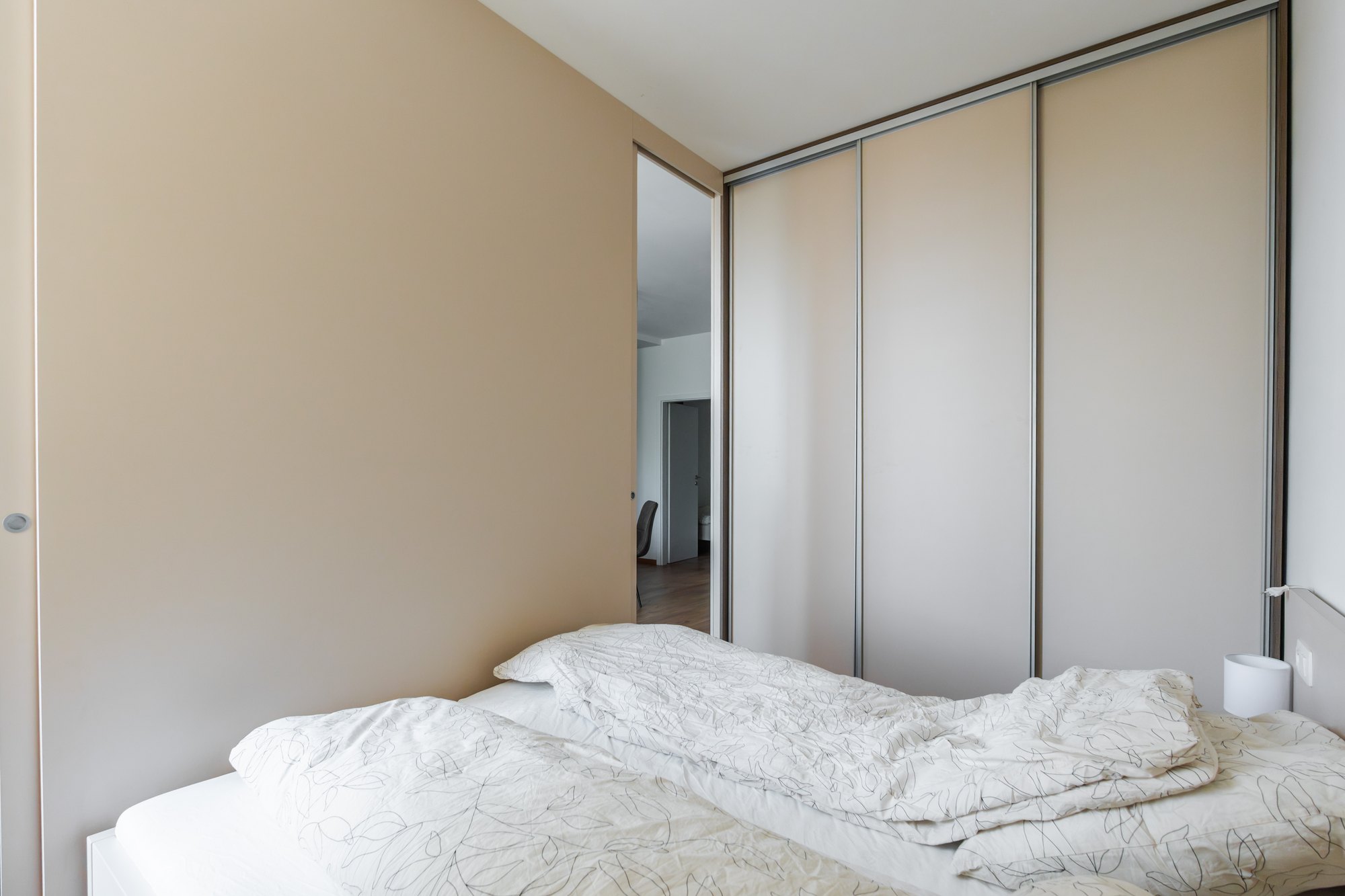 Built-in wardrobe with sliding doors from floor to ceiling in the bedroom, laminated chipboard in Satin and Brown Davos Oak décor, Bratislava.